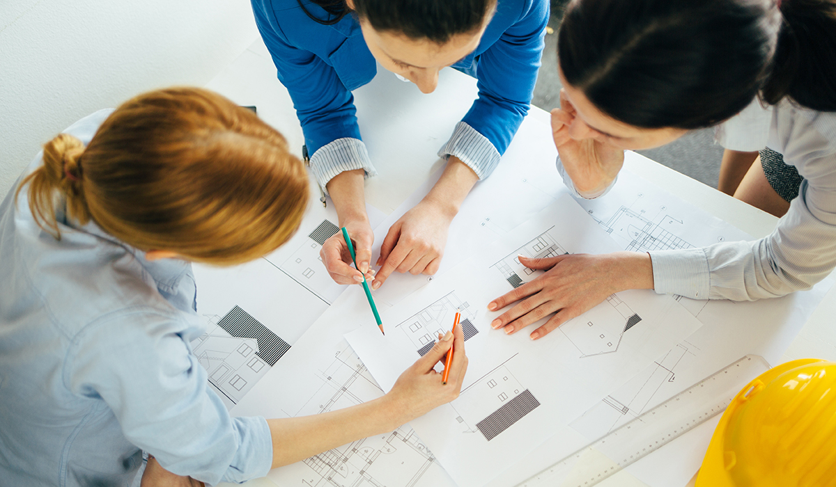 Three women from a Service Organization analyzing the blueprints of a Net Zero Home